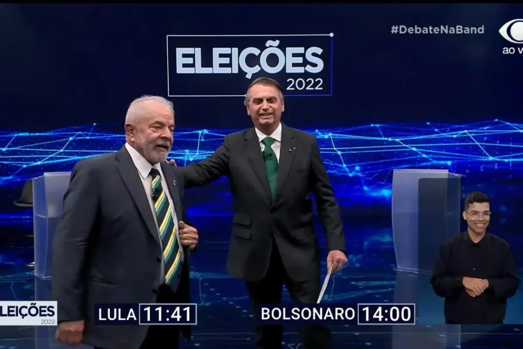Em primeiro debate do 2° turno Bolsonaro e Lula trocam sorrisos e ate mao no ombro
