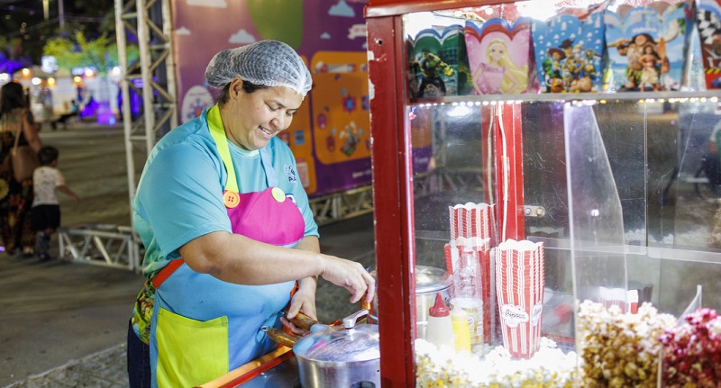 Comerciante trabalha em barraca de pipoca durante a Vila da Criança, na Orla de Atalaia