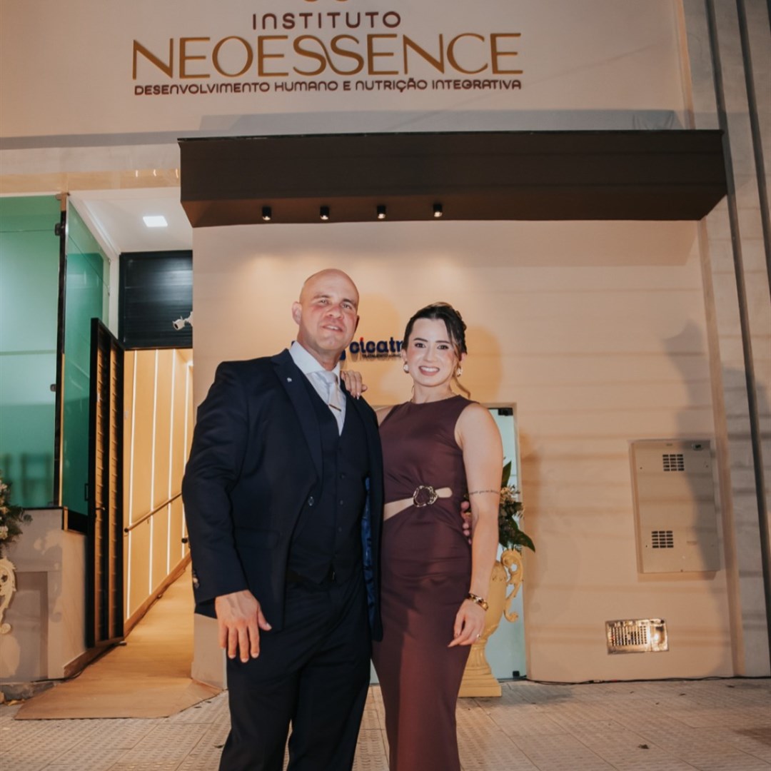 Inchaço e gases: exame não invasivo do Dr. Adelmo Alves chega a Itabaiana para investigar a saúde intestinal 1 Homem de terno escuro e mulher de vestido vinho posam abraçados na entrada do Instituto NeoEssence, à noite